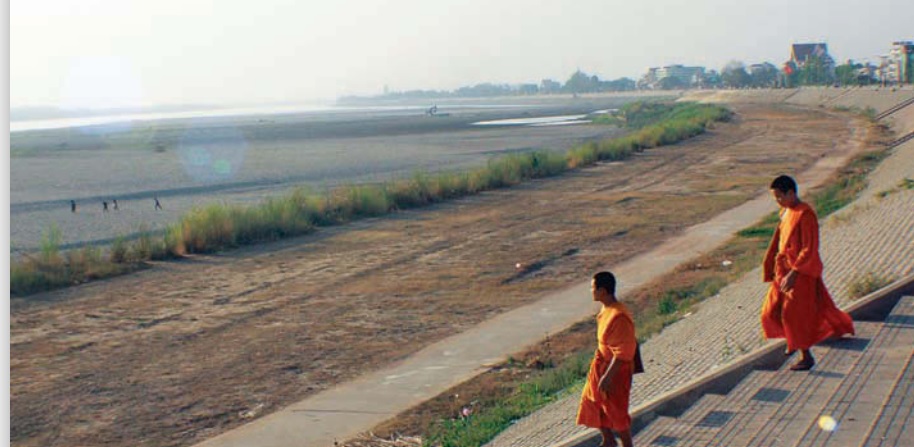 Dua biksu muda Laos melintas menuju hamparan Sungai Mekong yang mengering  (sumber gambar: Hypeabis/Roni Yunianto)
