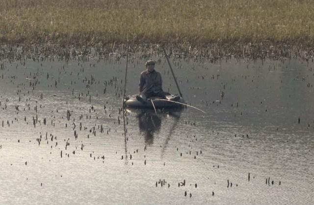 seorang nelayan di Korut  yang mencari ikan di danau dengan menggunakan ban bekas (sumber ericlafforgue.com)
