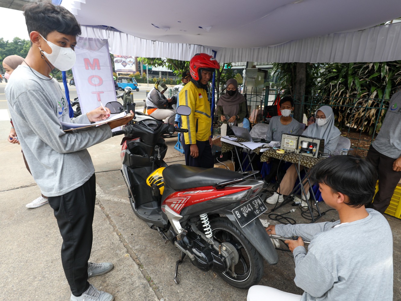 Petugas melakukan uji emisi kendaraan bermotor di Jakarta (Sumber foto: JIBI/Bisnis/Suselo Jati)