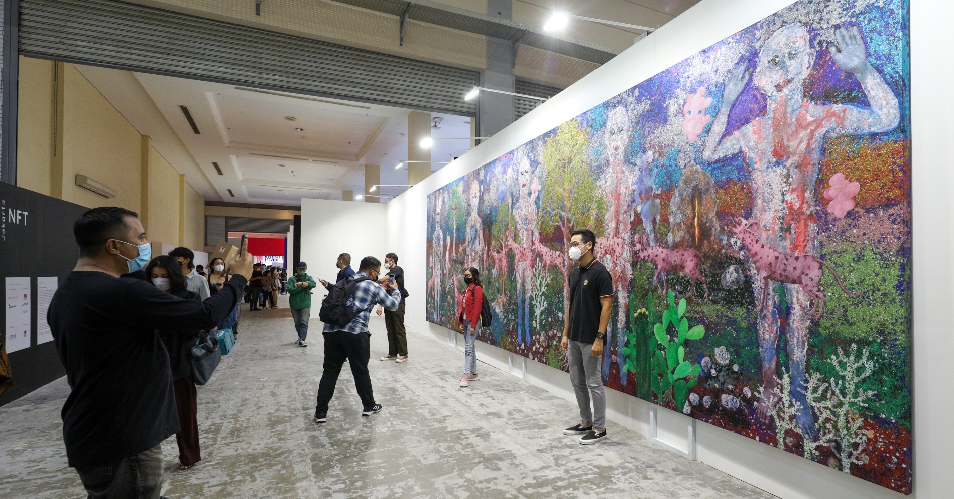 Pengunjung melihat karya Art Jakarta 2022 yang diselenggarakan di Jakarta Convention Center (JCC), Jakarta. (sumber gambar Hypeabis.id/ Suselo Jati)