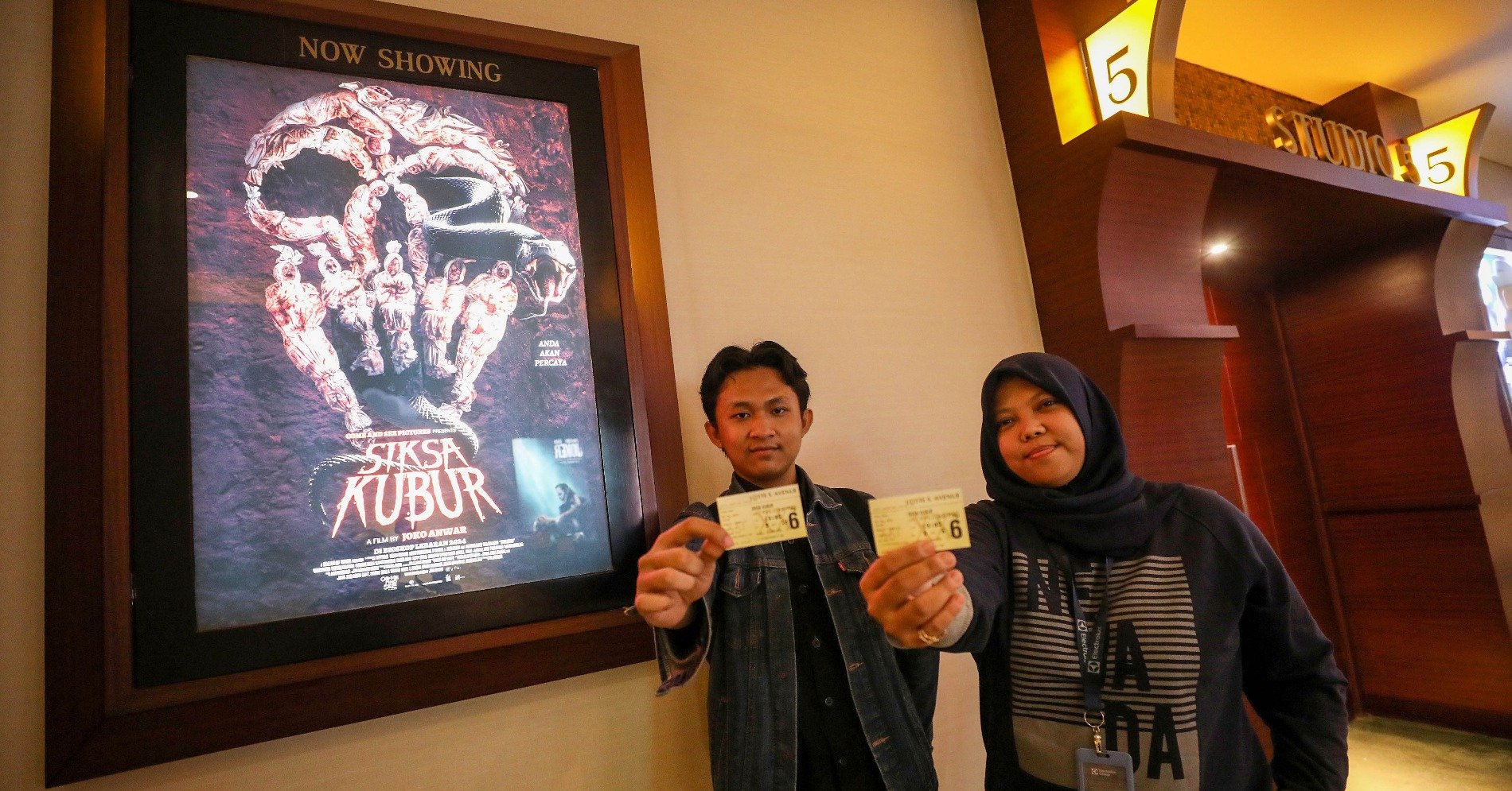 Pemenang giveaway nonton bareng film Siksa Kubur menunjukkan tiket bioskop di Jakarta, Jumat (3/5/2024) (Sumber gambar: JIBI/Bisnis/Eusebio Chrysnamurti)