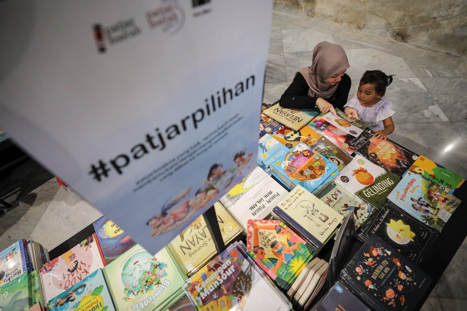 Seorang pengunjung dan anaknya di festival literasi dan pasar buku Patjar Merah Kecil di Pos Bloc Jakarta. (Sumber gambar: Hypeabis.id/Arief Hermawan P)