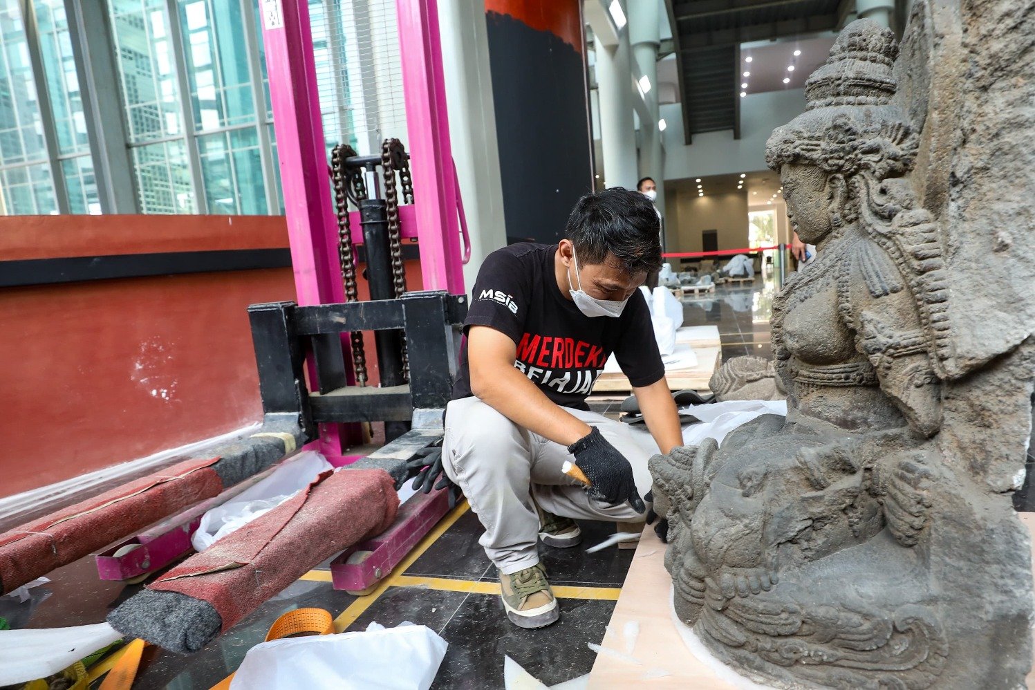 Seorang petugas sedang membersihkan salah satu arca di Museum Nasional Indonesia pada Selasa (17/9/24)