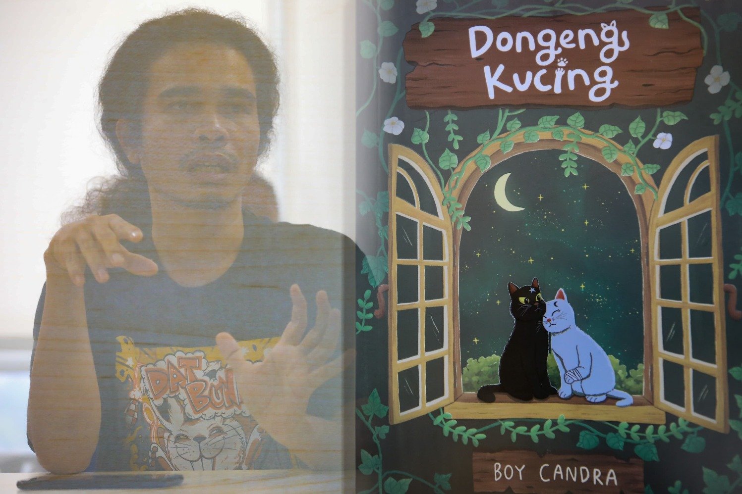 Penulis Boy Candra saat melakukan kunjungan media di kantor Hypeabis.id, Jakarta, Selasa (8/10/2024), dengan buku barunya yang berjudul Dongeng Kucing. (Sumber gambar: Hypeabis.id/Abdurachman)