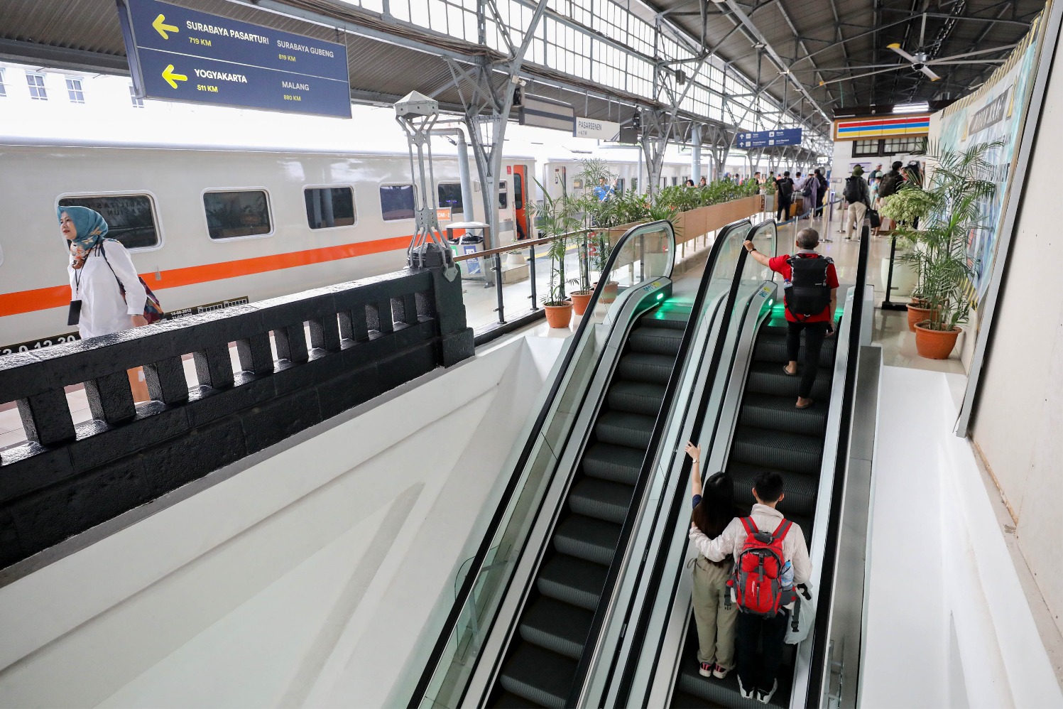 Calon penumpang menaiki eskalator di Stasiun Pasar Senen, Jakarta, Minggu (13/10/2024).