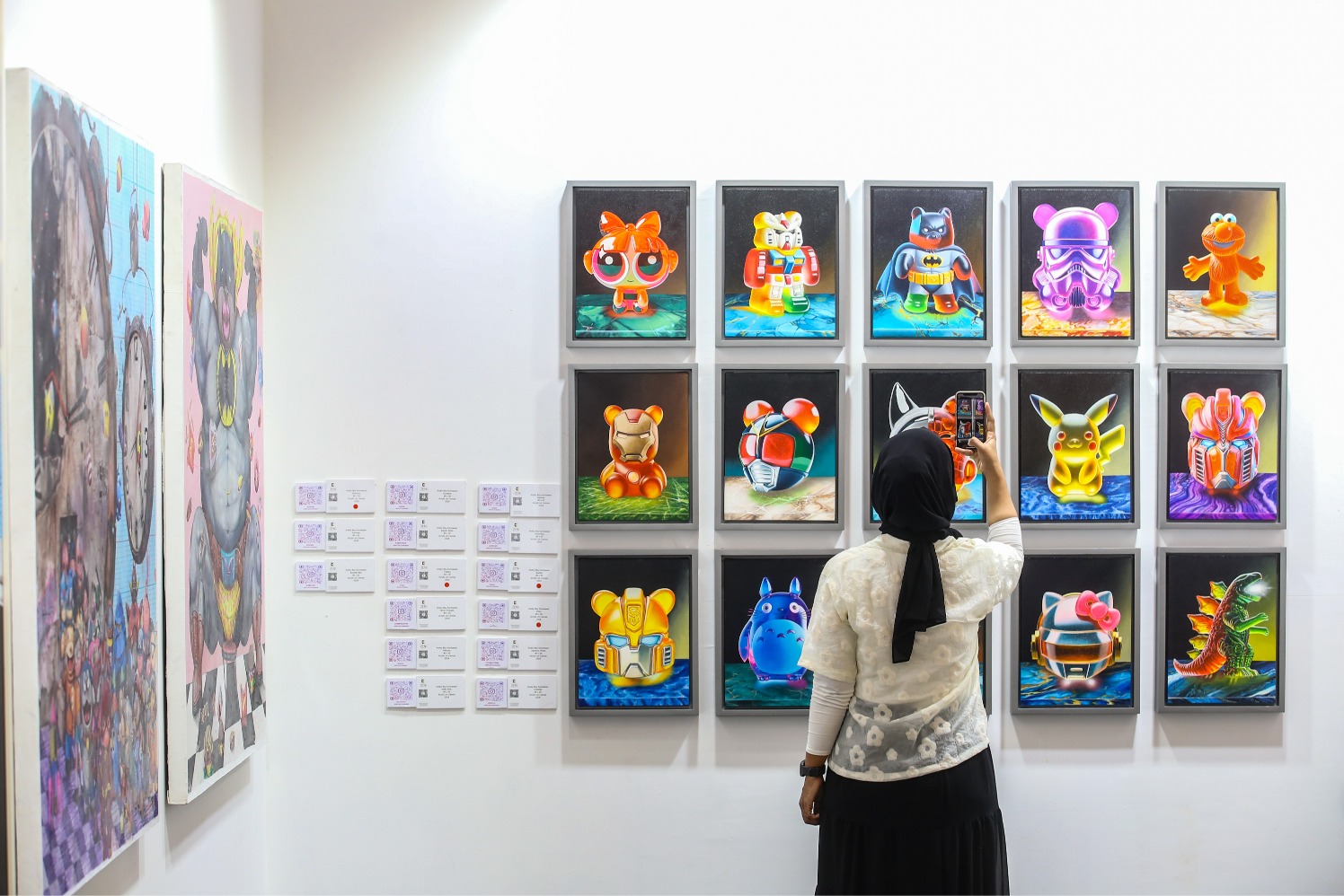 Pengunjung memotret karya Project: Zen1 yang dipamerkan di ArtMoments Jakarta 2024 , Jakarta, Jumat (9/8/2024). (Sumber gambar: JIBI/Bisnis/Abdurachman)