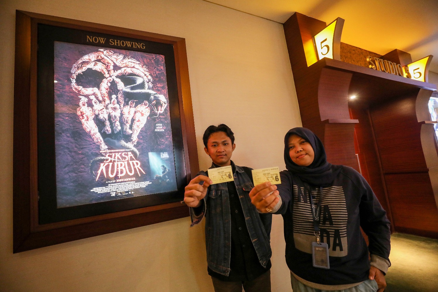 Pemenang giveaway nonton bareng film Siksa Kubur menunjukkan tiket bioskop di Jakarta, Jumat (3/5/2024). (Sumber gambar: JIBI/Bisnis/Eusebio Chrysnamurti)