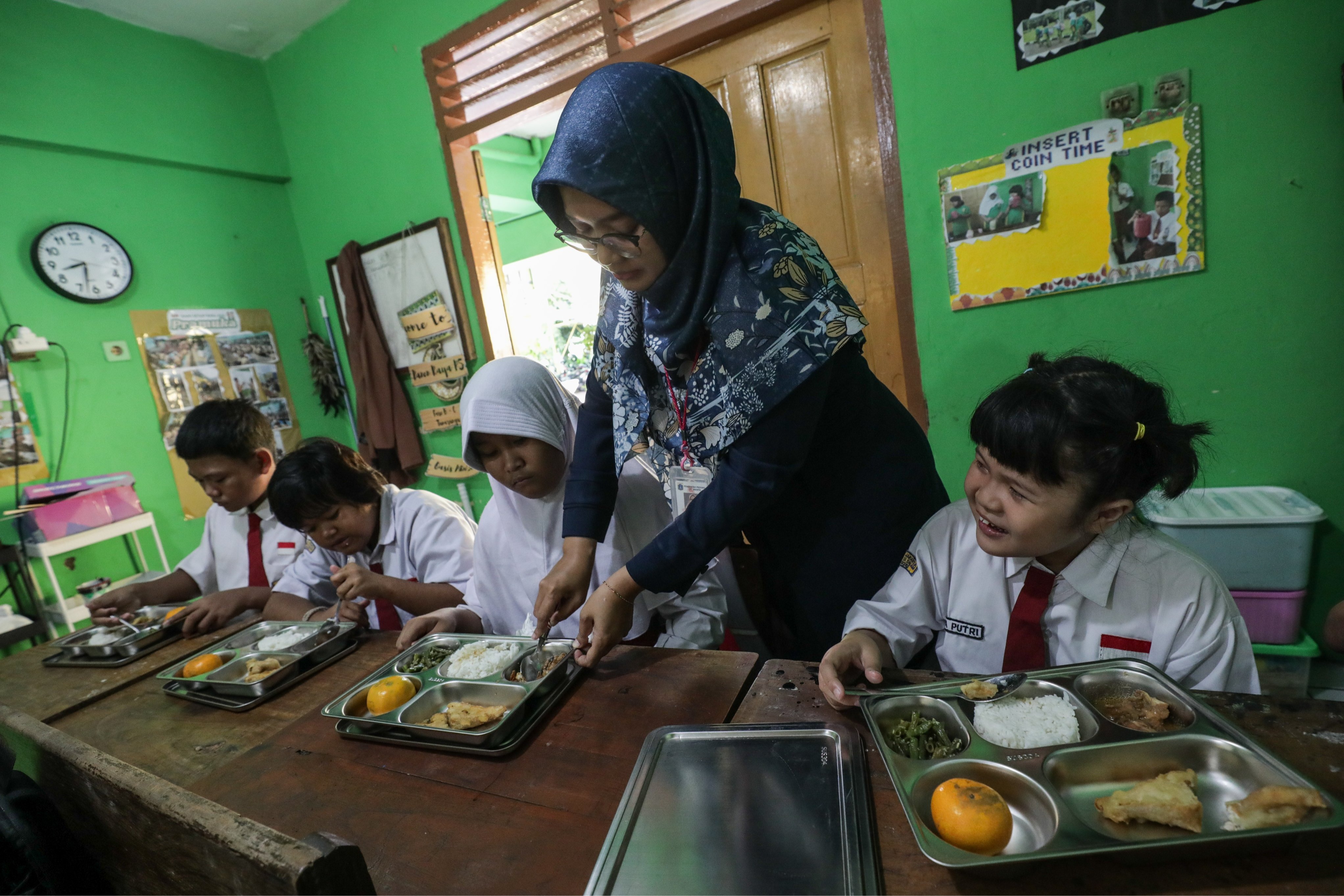 Siswa berkebutuhan khusus menyantap menu Makan Bergizi Gratis (MBG) di SLB Negeri 5 Jakarta, Jakarta, Senin (6/1/2025). (Sumber foto: JIBI/Hypeabis.id/Fanny Kusumawardhani)
