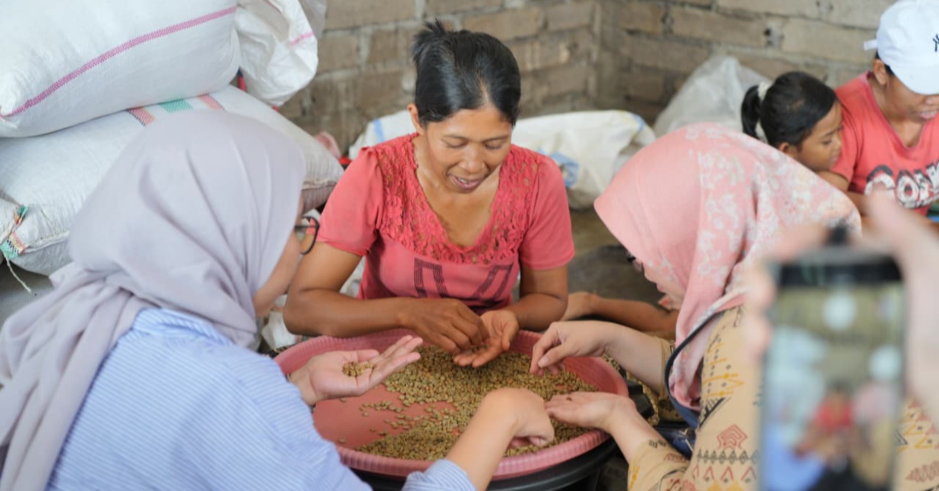 Ni Luh sedang memilah biji kopi secara manual bersama media (sumber : Kopi Kenangan) Ni Luh sedang memilah biji kopi secara manual bersama media (sumber : Kopi Kenangan)