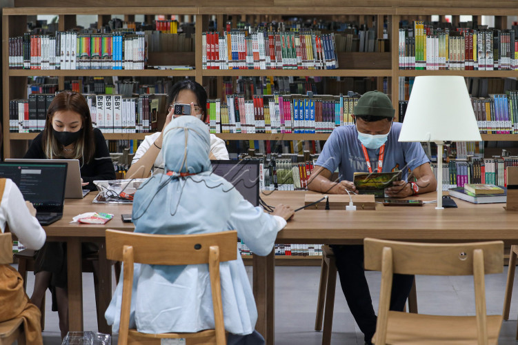 Mahasiswa mengerjakan tugas di Perpustakaan Taman Ismail Marzuki di Jakarta.