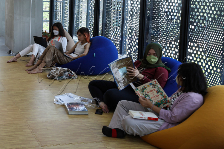Pengunjung berbincang disela-sela membaca buku di Perpustakaan Taman Ismail Marzuki di Jakarta.