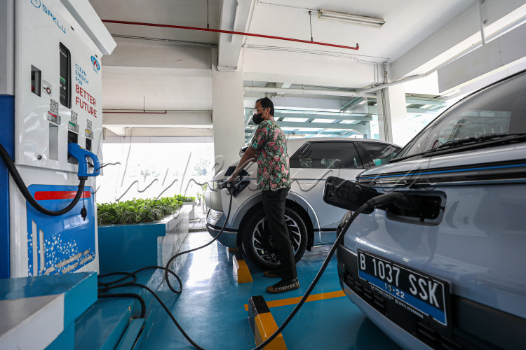 Pengendara mobil listrik mengisi daya di SPKLU Jakarta.