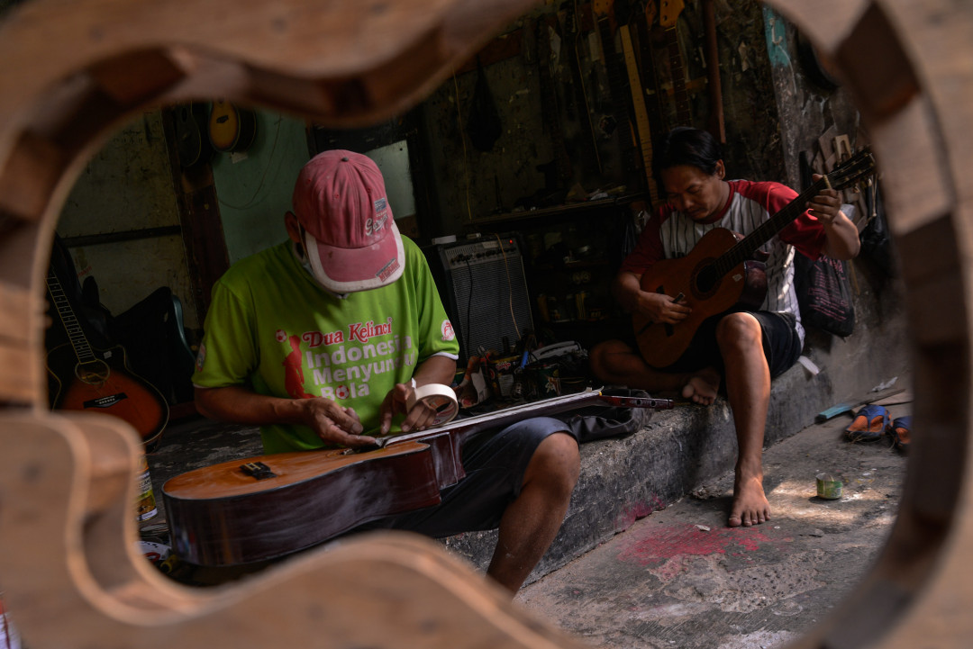 Perajin menyelsaikan pembuatan gitar di kasawan Tanjung Barat, Jakarta.