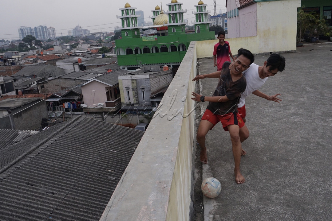 Sejumlah anak bermain bola di atap gedung kawasan Mampang, Jakarta.