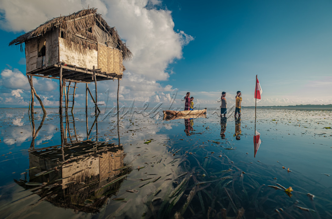 Anak-anak suku Bajo Sampela, di Desa Samabahari, Kecamatan Kaledupa, Kabupaten Wakatobi, Sulawesi Tenggara, melakukan hormat bendera di tempat yang sangat sederhana. Suku Bajo ini bermukim di tengah laut ( terpisah dari daratan), sehingga akses dari rumah ke rumah menggunakan perahu. Bila air laut surut, anak-anak suku Bajo bermain di hamparan lamun dengan menggunakan perahu.<br />
&nbsp;