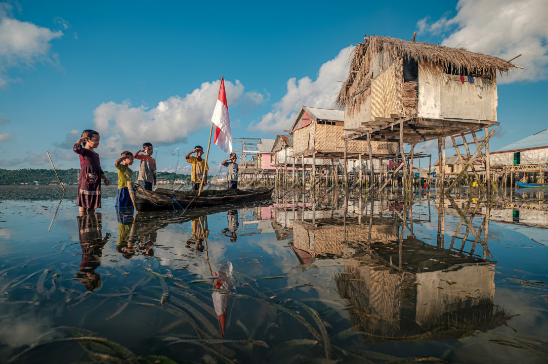 Anak-anak suku Bajo Sampela, di Desa Samabahari, Kecamatan Kaledupa, Kabupaten Wakatobi, Sulawesi Tenggara, melakukan hormat bendera di tempat yang sangat sederhana. Di tengah suasana air laut yang surut, anak-anak suku Bajo menegakkan tiang bendera di atas perahu lalu melakukan penghormatan bendera dengan sederhana.<br />
<br />
Dari sini kita belajar bahwa bila tak mampu mengharumkan Indonesia dengan prestasi, cukuplah kiranya dengan mencintai merah putih.&nbsp;Itulah bentuk cinta yang paling sederhana untuk Indonesia.