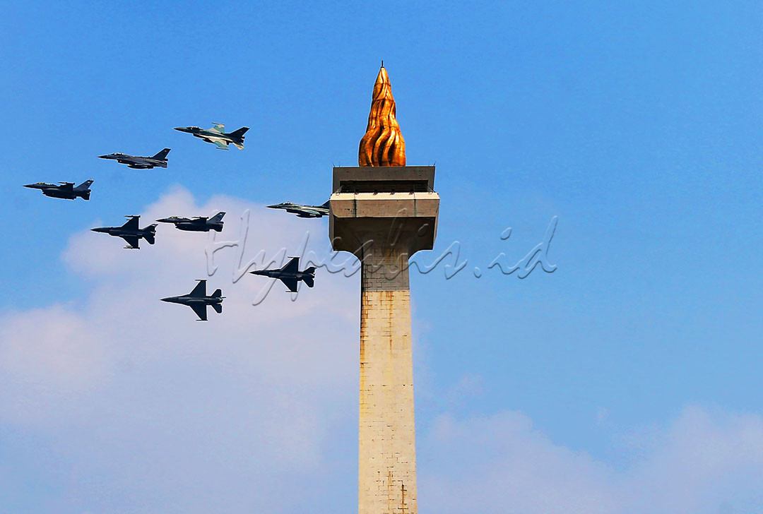 Delapan pesawat tempur F-16 TNI AU dengan call sign Garuda Flight membentuk Arrow Head Formation saat upacara detik-detik Proklamasi Kemerdekaan Republik Indonesia melintas di kawasan Monumen Nasional (Monas) Jakarta pada ketinggian 1.000 kaki, Selasa (17/08/2021).