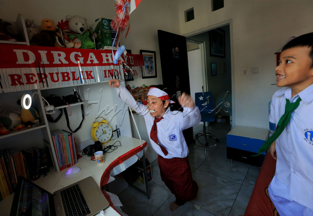 Ekspresi kemenangan pelajar sekolah dasar (SD) yang di support adiknya yang berbeda sekolah saat mengikuti lomba makan kerupuk secara online dalam rangka memeriahkan HUT Kemerdekaan ke-76 RI dari rumahnya di tengah pandemi Covid19 di kawasan Graha Raya, Tangerang Selatan, Banten, Senin (16/08/2021).
