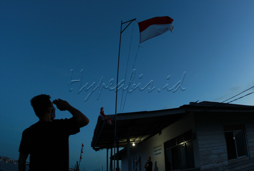 Seorang warga sedang menghormati bendera Merah Putih di Pulau Bintan 30 Agustus 2020.