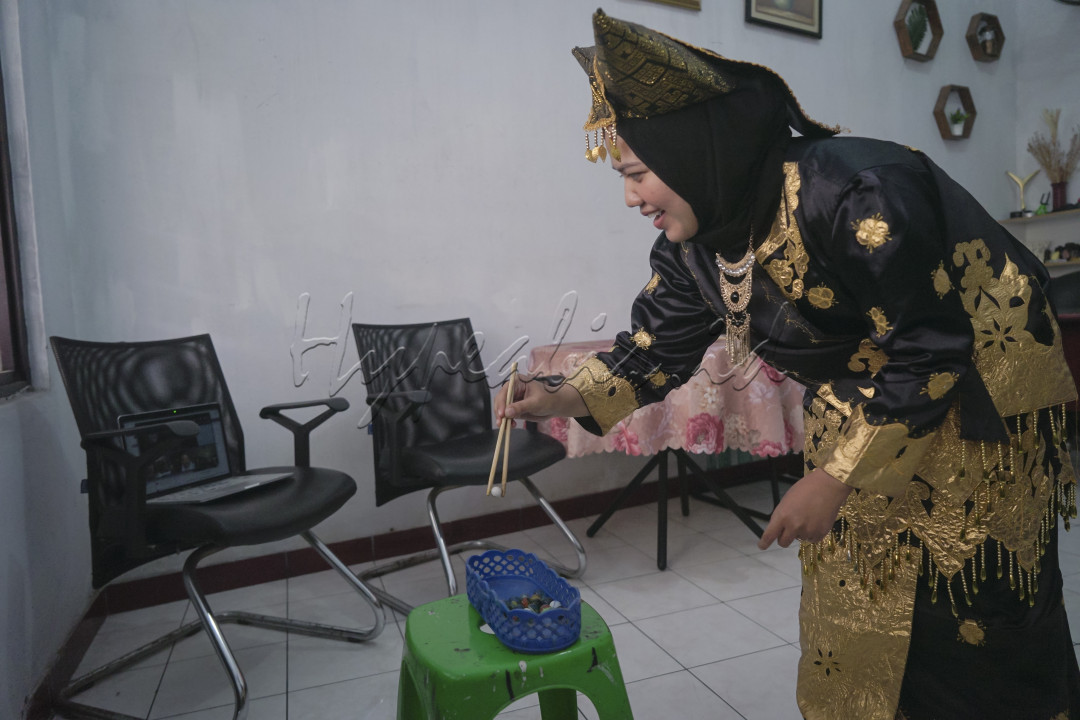 Olivia Chyntia Dewi, karyawan sebuah perusahaan swasta mengenakan baju adat tradisional Minang&aring;&ccedil;kabau mengikuti lomba memindahkan kelereng secara daring di rumah masing-masing karyawan yang diselenggarakan oleh salah satu divisi perusahaan di kantornya, Tangerang, Provinsi Banten, 16 Agustus 2021. Kegiatan tersebut diisi dengan berbagai kompetisi seperti; Lomba lomba bekel, lomba makan kerupuk, lomba gerak kelereng, dan lomba busana daerah dalam rangka memeriahkan HUT RI ke-76 di tengah pandemi COVID-19. (Foto : Kurniawan Mas'ud)