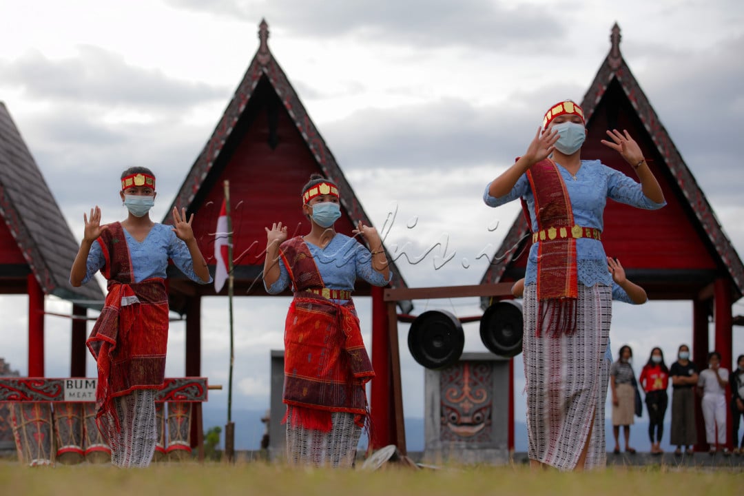 Sejumlah penari tortor adat batak toba tengah melakukan tarian di lapangan desa Meat, Tampahan, Toba, Sumatera Utara. Tarian ini untuk menyambut kemerdekaan Republik Indonesia yang ke-76 di bibir danau toba.