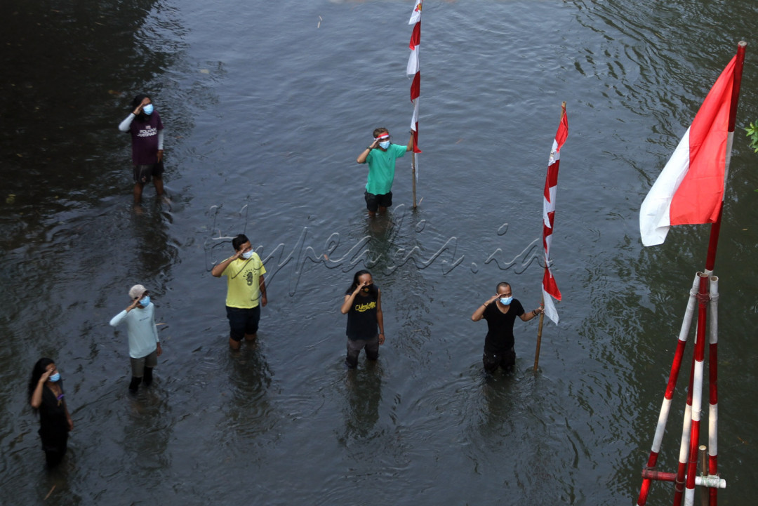 Aktivis lingkungan melakukan upacara bendera memperingati kemerdekaan ke-76 RI di aliran kali Ciliwung, Depok, Selasa (17/8). Walau upacara dilakukan secara sederhana tapi dilakukan dengan khidmat dengan pengbaran bendera ditengah aliran kali CIliwung