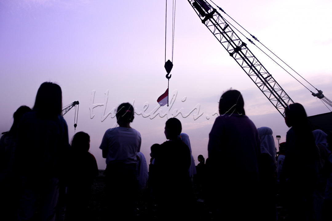 Anak-anak dari Komunitas Kelas Jurnalis Cilik melakukan upacara bendera HUT ke-76 Republik Indonesia di Belah Kapal, Cilincing, Jakarta Utara, Selasa (17/8). Pengibaran bendera di lakukan menggunakan alat berat crane. Selain meningkatkan nasionalisme sejak dini upacara tersebut juga mengasah kemampuan percaya diri anak untuk menjadi panitia upacara