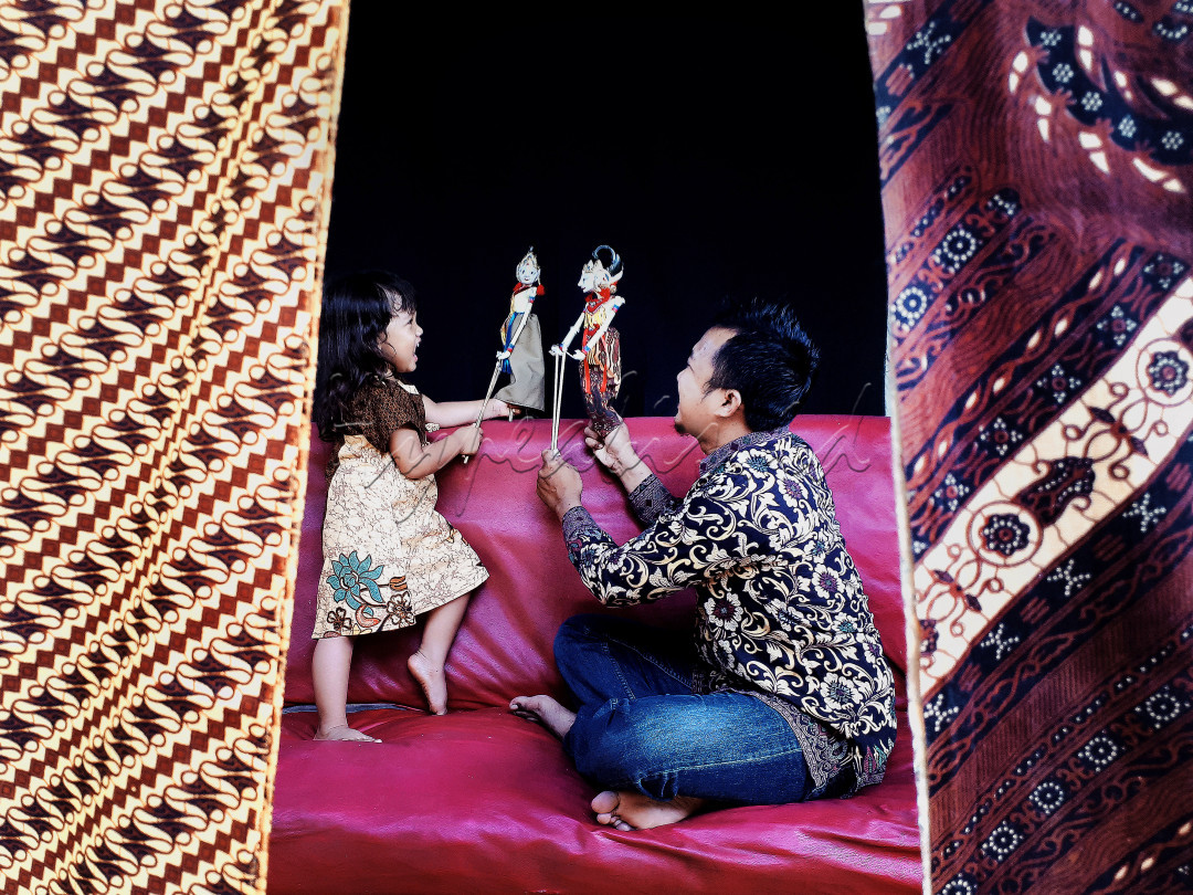 Dimusim pandemi ini, kita harus selalu mengikuti anjuran pemerintah, salah satunya yakni kita harus tetap dirumah saja.<br />
Meskipun dirumah, kita juga bisa melakukan kegiatan yang bermanfaat dan menyenangkan.<br />
Seperti yang terlihat difoto ini, terlihat ada anak yang sedang bermain wayang dengan ayahnya.<br />
Ekspresi anak dan ayahnya tersebut juga terlihat sangat senang dan bahagia, meskipun hanya bermain dirumah saja.<br />
Dengan kegiatan tersebut, anak juga bisa bermain sambil belajar tentang kesenian tradisional.