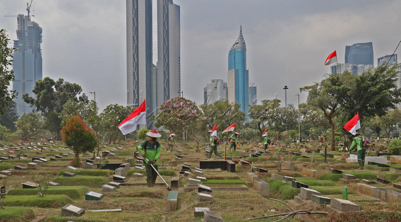 Petugas Pertamanan dan Kehutanan Kota Jakarta Pusat memakai atribut kemerdekaan saat melakukan pekerjaan pemotongan rumput di TPU Karet Bivak, Tanah Abang, Jakarta Pusat, Sabtu (16/8/2020). Dalam rangka menyambut HUT RI ke-75 para petugas akan bekerja dengan mengenakan atribut ini sampai hari kemerdekaan tiba pada &nbsp;tanggal (17/8).<br />
&nbsp;