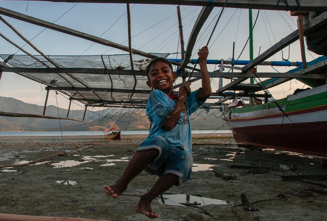 Ekspresi kegembiraan dan kemerdekaan bermain seorang anak suku Bajo di Pulau Boleng, Flores - NTT