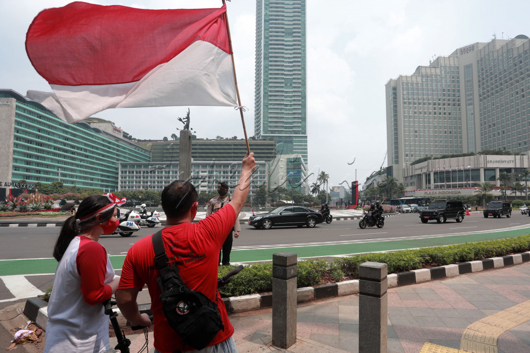 Kibarkan Merah Putih<br />
Warga mengibarkan bendera merah putih saat mobil iring-iringan Wakil Presiden Ma'ruf Amin melintasi kawasan Bundaran HI, Selasa (17/8/2021). Momen perayaan HUT Kemerdekaan ke-76 Republik Indonesia pada masa pandemi COVID-19 dilaksanakan dengan sederhana.