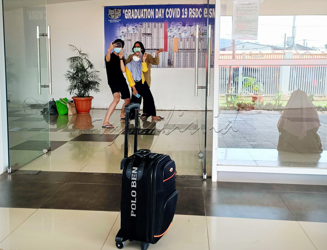 HAPPY ENDING: Pasien yang telah sembuh atau dinyatakan negatif covid-19 melakukan selfie saat akan meninggalkan Rumah Sakit Darurat Covid-19 (RSDC) Wisma Atlet Kemayoran, Jakarta, Rabu (30/06/2021).