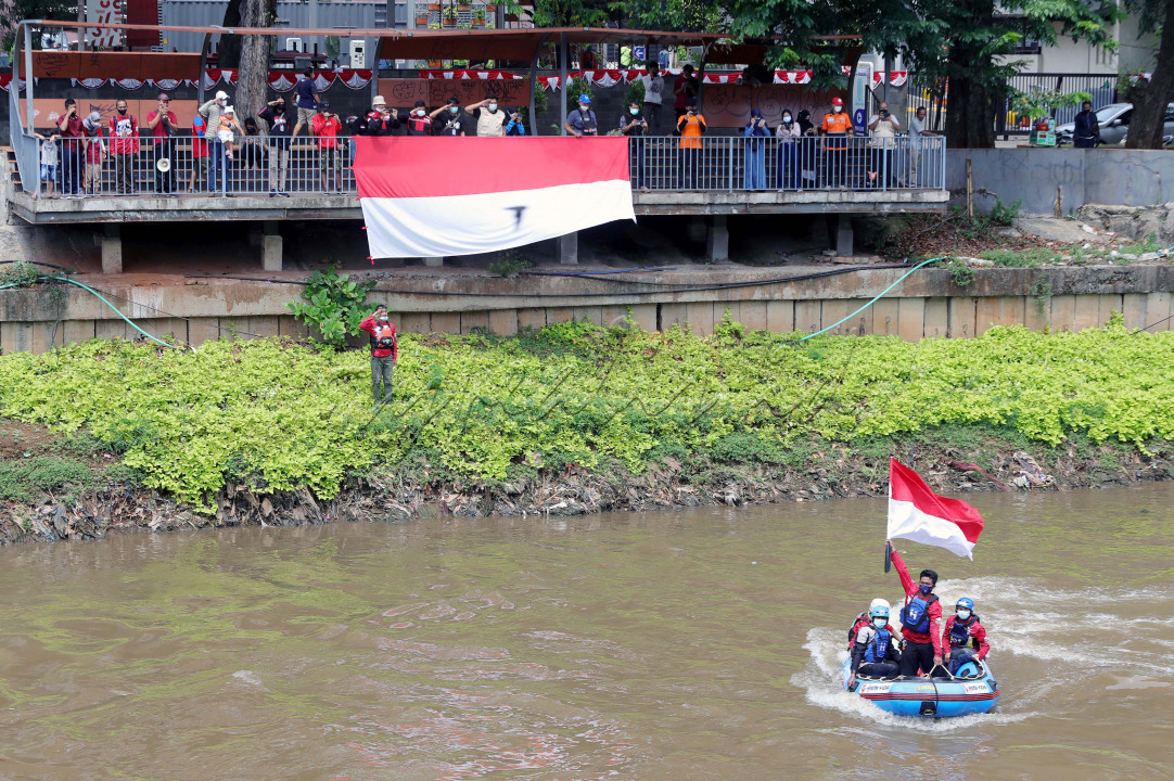 Gabungan Team Relawan Rescue melakukan pembentangan bendera ukuran 10x5 meter di atas sungai ciliwung, Minggu (22/8/2021). Kegiatan ini dalam rangka memperingati hari Kemerdekaan, sekaligus mengkampanyekan kepedulian masyarakat terhadap kebersihan sungai dari sampah.
