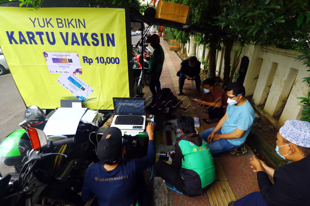 Warga mengantre saat melakukan&nbsp;pencetakan kartu vaksin Covid-19 di Alun-Alun Cimahi, Kota Cimahi, Jumat 13 Agustus 2021. Seiring adanya penerapan&nbsp;sertifikat vaksin&nbsp;Covid-19 sebagai syarat perjalanan dan&nbsp;masuk mall menjadi peluang bisnis baru bagi pembuat kartu vaksin. Dalam sehari, pembuat kartu vaksin ini mampu menerima pesanan hingga 100 kartu dengan harga Rp. 10.000 perkartu.