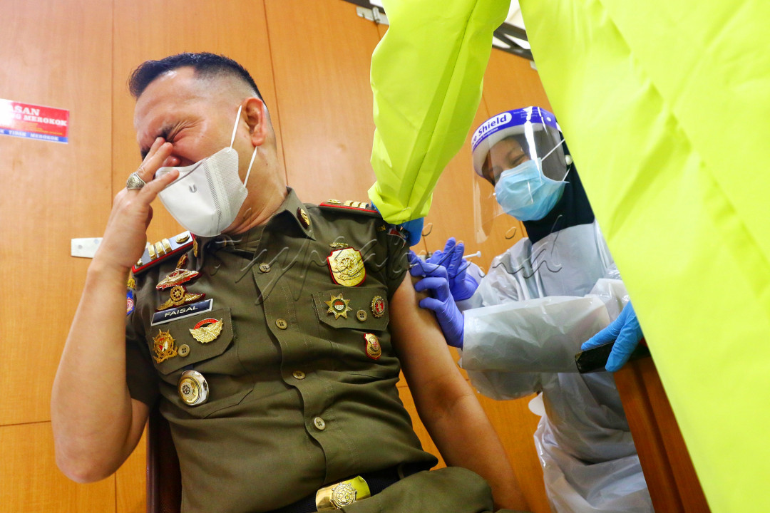 Petugas kesehatan menyuntikkan&nbsp;vaksin&nbsp;Covid-19 kepada salah satu anggota Satpol PP di Kompleks Pemkot&nbsp;Cimahi, Jalan Raden Demang Hardjakusumah, Kota&nbsp;Cimahi, Senin (1/3/2021). Vaksinasi Covid-19 terus digencarkan untuk mempercepat terbentuknya Herd Immunity guna&nbsp;memutus rantai penularan Covid-19.<br />
&nbsp;