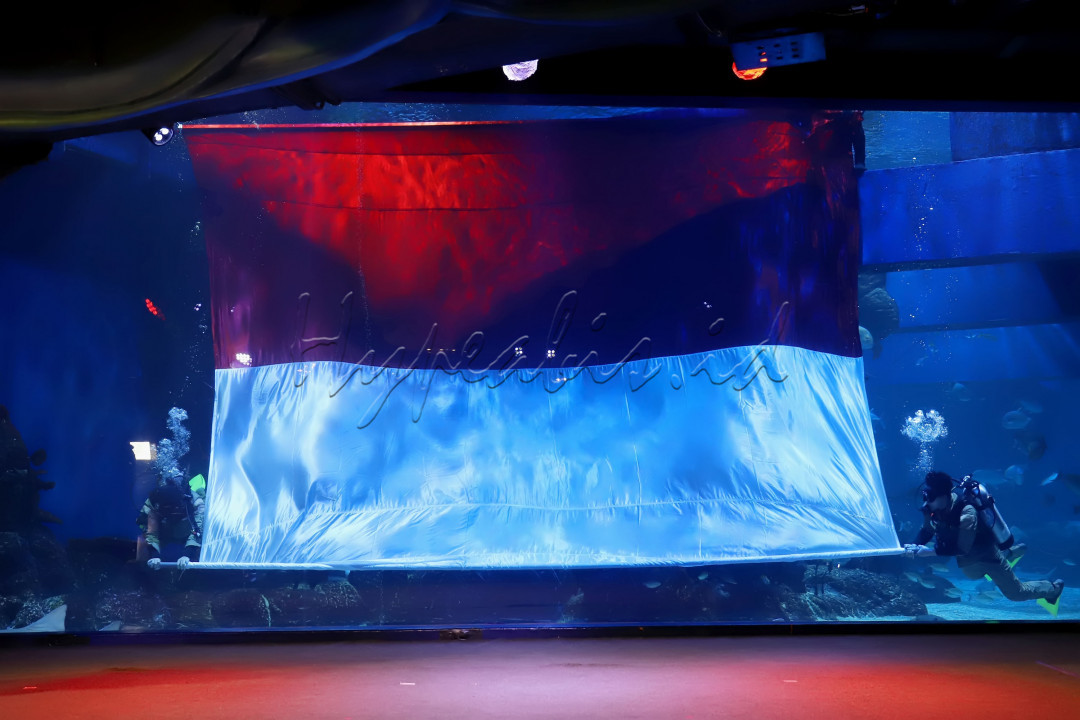Penyelam dengan kostum pejuang di Jakarta Aquarium, Neo Soho Mall, Jakarta Barat, Selasa (17/8/2021). Pengibaran bendera Merah Putih raksasa dengan ukuran 8&times;5 meter dibawah air tersebut dalam rangka memperingati Hari Ulang Tahun Kemerdekaan Republik Indonesia ke-75.&nbsp;