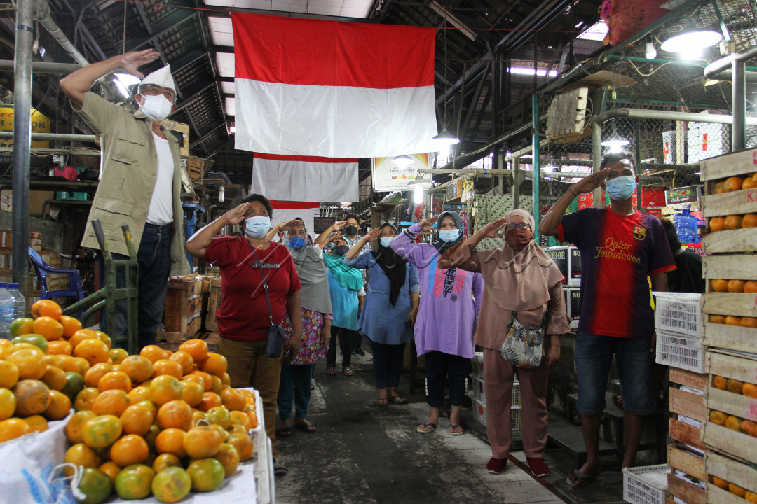 Relawan dan pedagang pasar gede hormat bendera memperingati HUT RI ke 76 th di dalam pasar gede Solo.<br />
&nbsp;