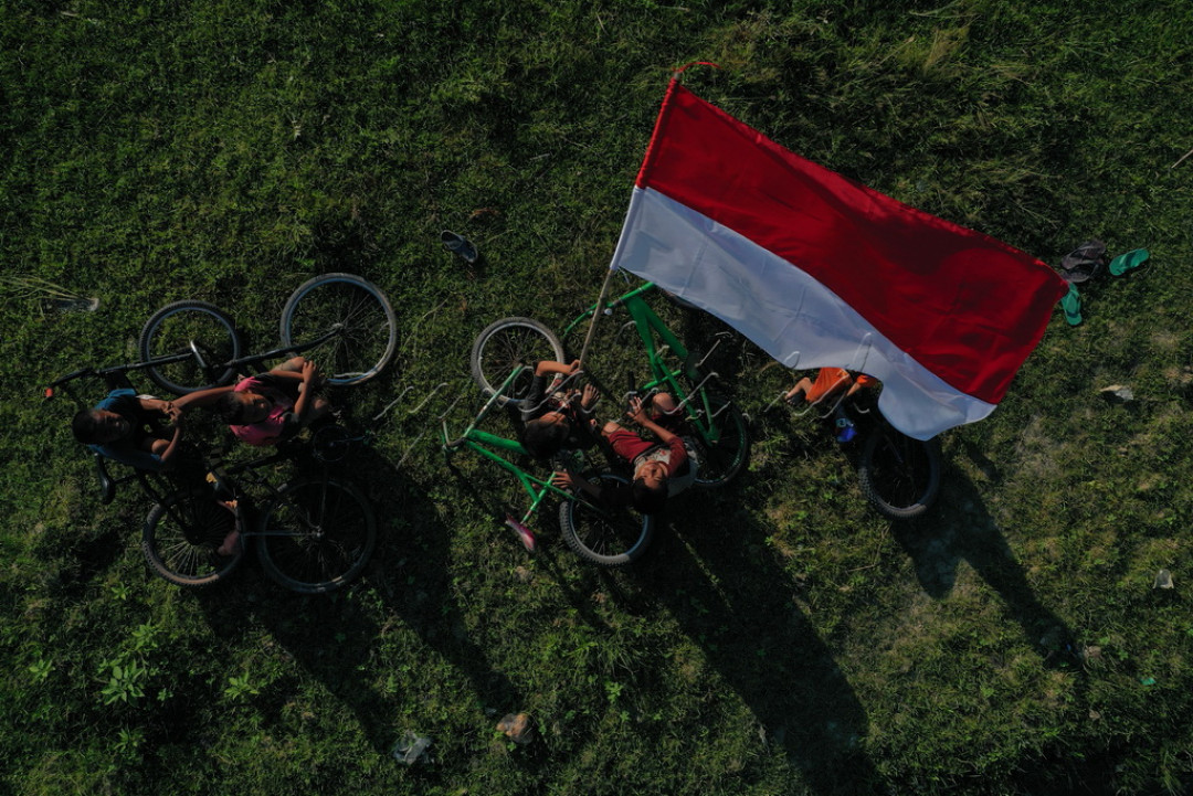 Sejumlah anak-anak sedang mengibarkan bendera merah putih di pinggiran sawah di wilayah Kec. samaturu kab. Kolaka, Sulawesi tenggara