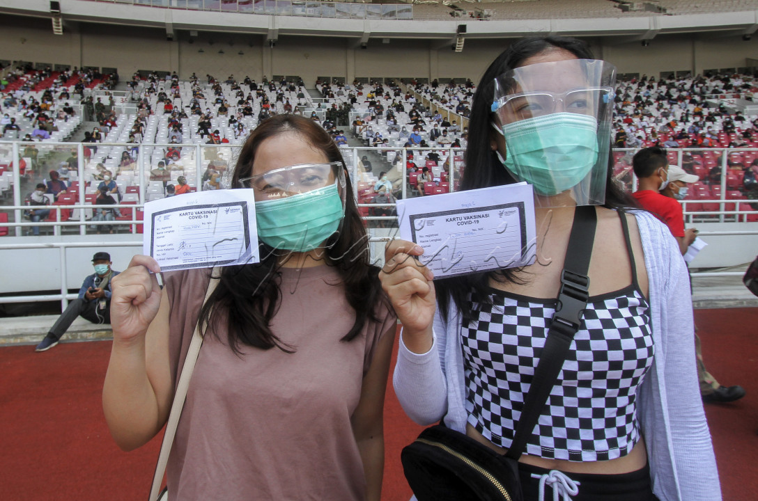 JAKARTA, INDONESIA, 3 Juli : Peserta memperlihatkan sertivikat usai menerima suntikan vaksin COVID-19 di stadion Gelora Bung Karno, Jakarta, Indonesia pada Sabtu 3 Juli 2021. Vaksin yang diperuntukkan umur 12 tahun keatas tersebut di ikuti sebanyak 11.500 warga yang ber KTP DKI Jakarta. Minat masyarakat ini melebihi target pemrov DKI yang menargetkan hanya 8ribu hingga 10 ribu peserta setiap hari.&nbsp;