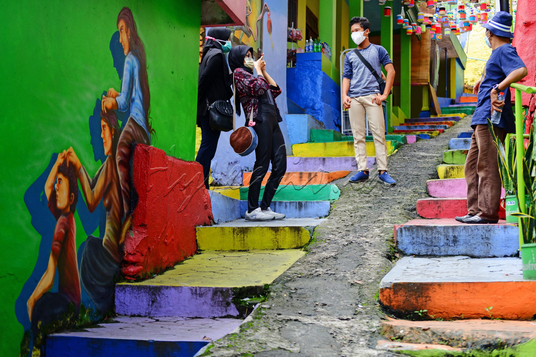 Sejumlah wisatawan dengan prokes menikmati pesona keindahan Kampung Warna Warni di Kota Malang. Kampung yang hits penuh warna dan mural ini sempat tutup selama pandemi, dan kemudian dibuka kembali dengan penerapan protokol kesehatan bagi pengunjung nya.<br />
<br />
Mural-mural kreatif karya anak kampung memenuhi gang-gang kampung wisata ini, menandakan mereka bebas berkreasi dan sebagai bentuk ekspresi kemerdekaan. Ketaatan pengunjung dalam menerapkan prokes pun menjadikan mereka tetap bebas merdeka untuk menikmati pesona Indonesia.