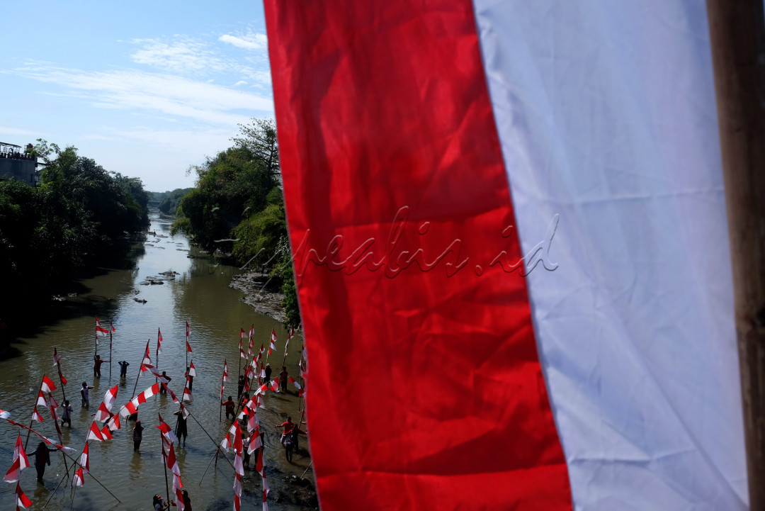 Warga dan aktivis lingkungan mengikuti upacara bendera di Sungai Kalianyar, Banjarsari, Solo, Jawa Tengah, Senin (17/8/2020). Upacara di sungai tersebut digelar untuk peringatan HUT Ke-75 RI sekaligus sebagai kampanye pelestarian sungai.