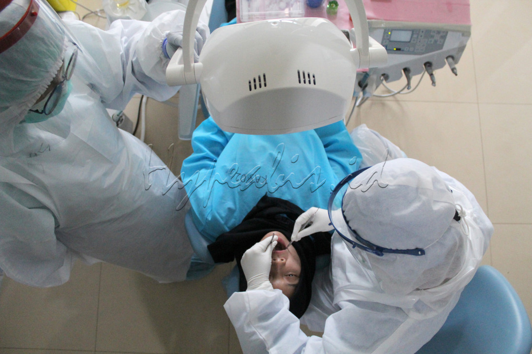 Dokter Gigi melakukan pemeriksaan gigi dengan menggunakan APD Level III, sedangkan pasien dilengkapi dengan gown pengaman. Dalam masa pandemi ini kesehatan gigi menjadi salah satu cerminan kesehatan tubuh secara menyeluruh guna menambah daya tubuh dalam menghadapi pandemi.&nbsp;