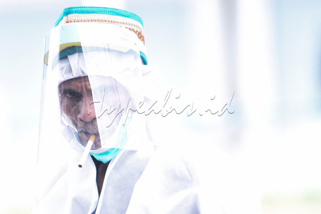 Petugas TPS 005 Desa Ibul Besar III Kecamatan Pemulutan Kabupaten Ogan Ilir dengan mengunakan hazmat tetap eksis dengan rokok yang terselip dimulutnya saat bertugas pad Pilkada serentak Tahun 2020 di Sumatera Selatan, Rabu (9/12/2020).Pemungutan suara dilakukan dengan penerapan protokol kesehatan secara ketat.<br />
<br />
&nbsp;