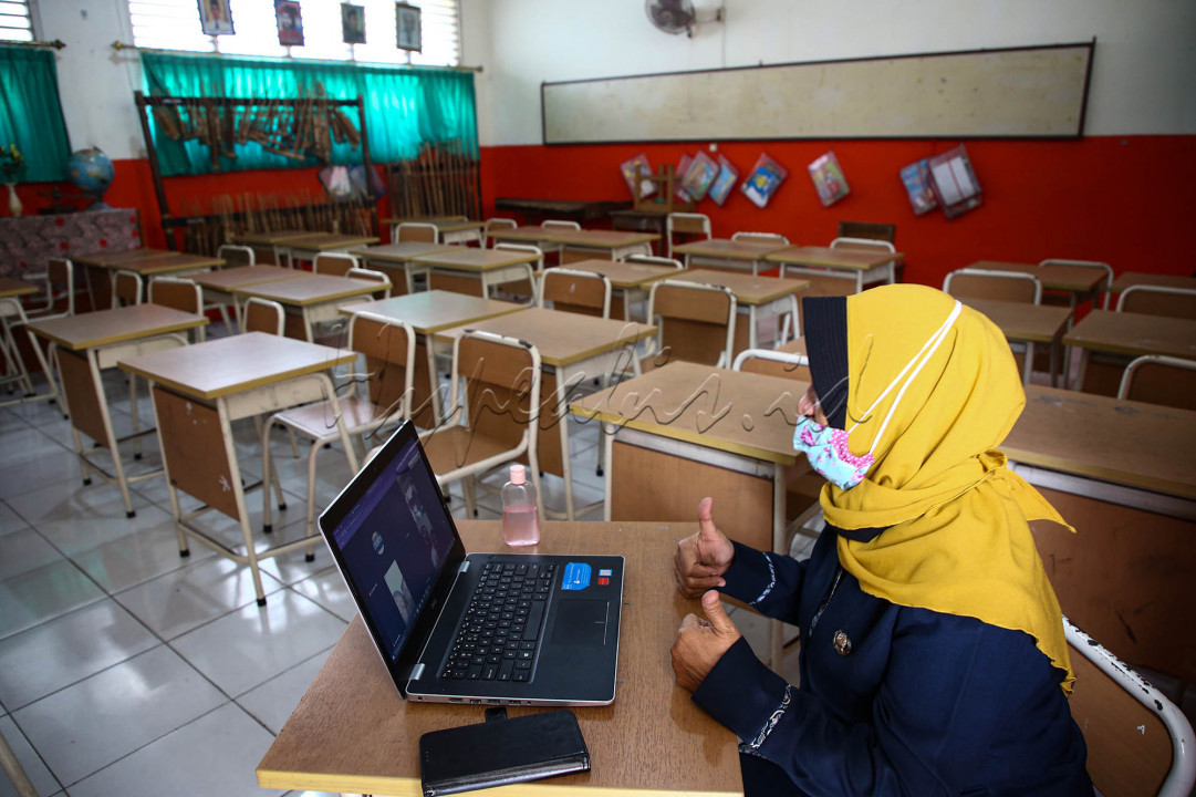 Nur Janah, guru kelas 1B, SD Negeri 05 Pagi Joglo, Kembangan, Jakarta Barat mengajar dalam pembelajaran jarak jauh (PJJ) secara daring dengan memanfaatkan internet sekolah, Selasa (4/8/2020). Berbagai upaya dilakukan baik dari pihak sekolah maupun siswa agar tetap bisa melaksanakan pembelajaran di tahun ajaran baru 2020/2021 di tengah pandemi Covid-19. Kendala seperti persoalan jaringan internet hingga keterbatasan kepemilikan gawai siswa menjadi kendala dalam pembelajaran jarak jauh.&nbsp;<br />
&nbsp;