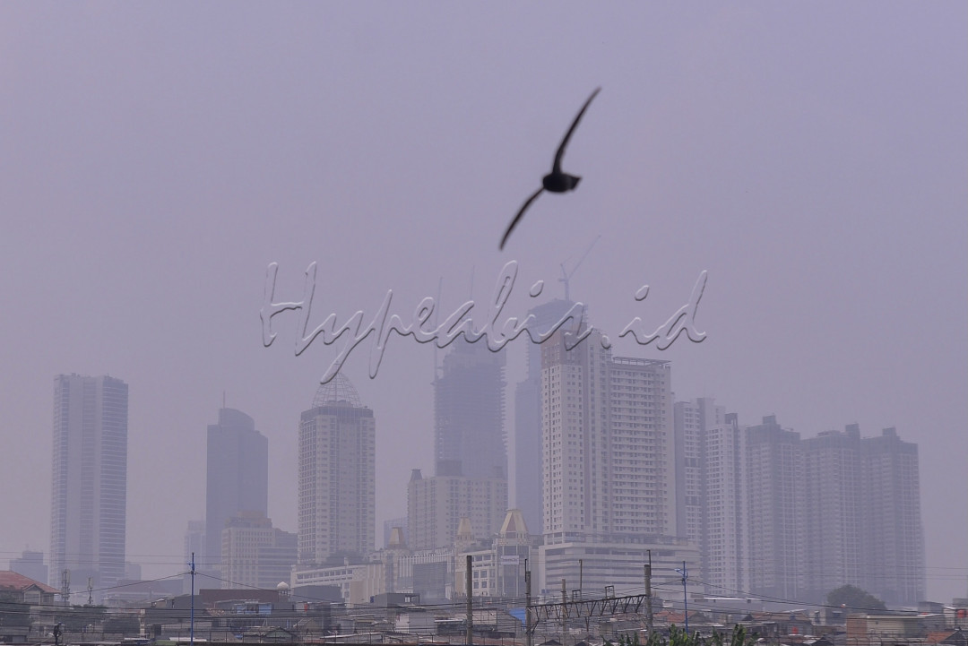 Langit abu-abu menyelimuti deretan gedung bertingkat di Jakarta.