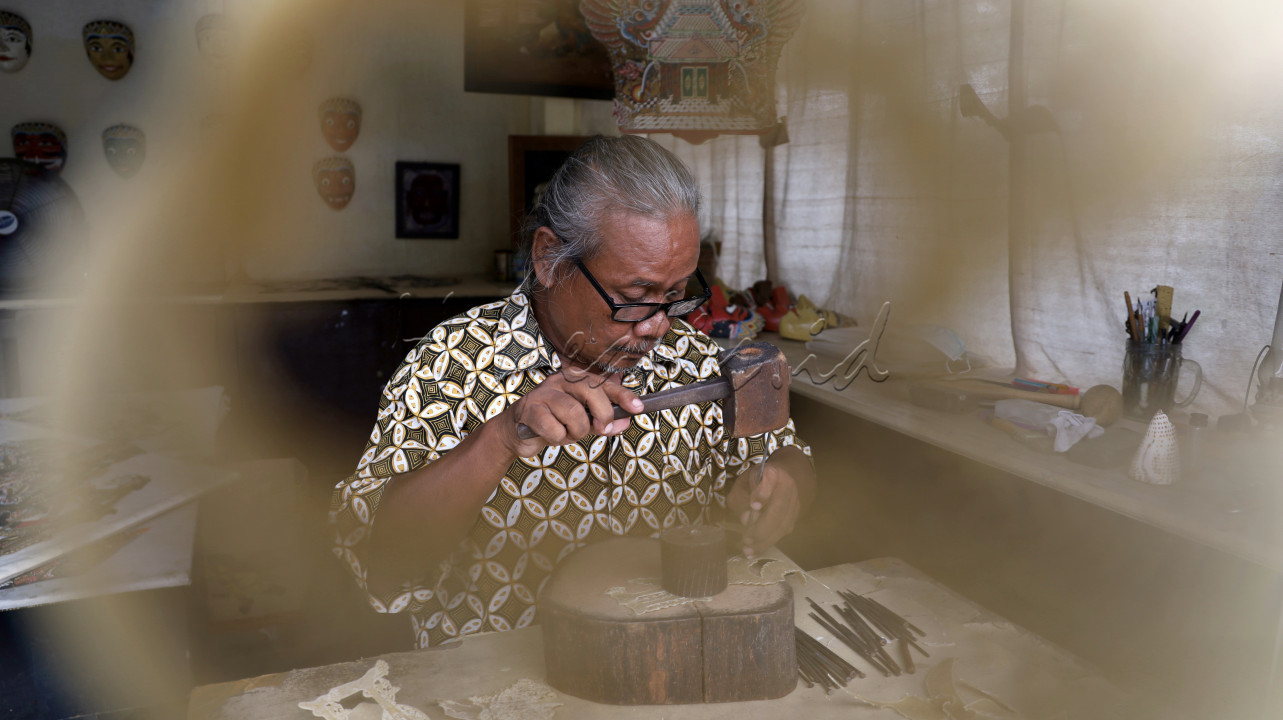 Perajin wayang kulit, Pak Suroso, sedang menatah wayang kulit di workshopnya yang berada di Museum Sonobudoyo Yogyakarta. Pekerjaan ini memerlukan kecermatan dan ketelitian agar hasilnya bagus. Karya Pak Suroso dibeli oleh wisatawan baik asing maupun lokal yang berkunjung ke Museum Sonobudoyo.