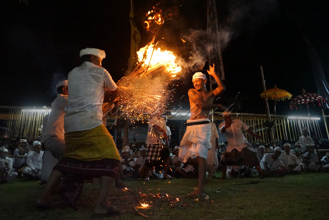 Sebuah tradisi yang berlangsung di Klungkung, Bali. Pada upacara ini, para pengayah yang dalam kondisi setengah<em> trance&nbsp;</em>meminta sarana geni / api, untuk sebuah persembahan.