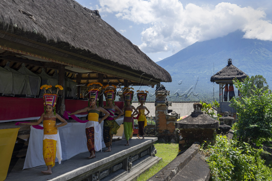 Para penari Rejang dengan dandanan indah warna warni, disaksikan oleh gunung Agung yang bersahaja