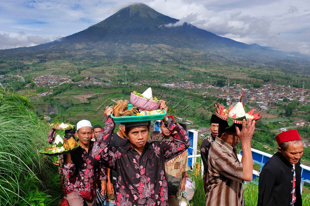 Warga mengusung tumpeng dan ingkung ayam saat tradisi Merti Desa Petarangan di puncak bukit Botorono kawasan lereng gunung Sumbing, Petarangan, Kledung, Temanggung, Jateng, Jumat (26/11/2021).&nbsp;