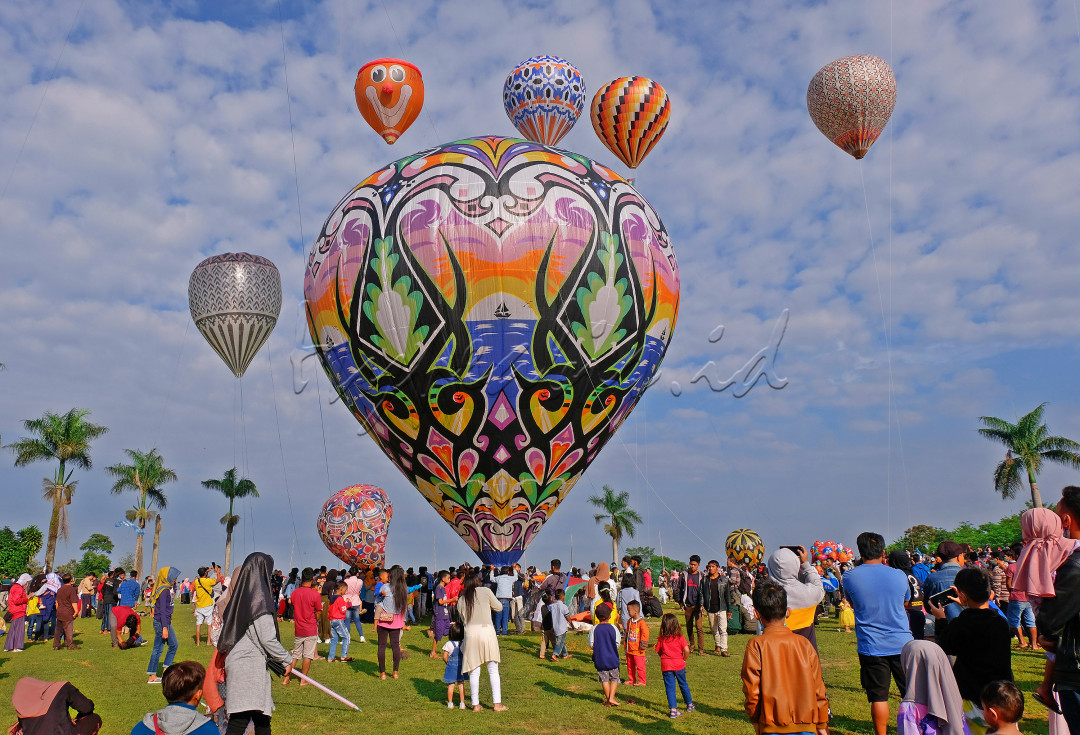 Sejumlah warga menyaksikan penerbangan balon udara di lapangan desa Kembaran, Kalikajar, Wonosobo, Jateng, Rabu (19/5/2021). Tradisi penerbangan balon udara tradisional rutin dilaksanakan masyarakat setempat pada hari ke tujuh Lebaran, agar tidak mengganggu lalu lintas udara balon udara ditambatkan menggunakan tali dengan ketinggian tertentu.&nbsp;